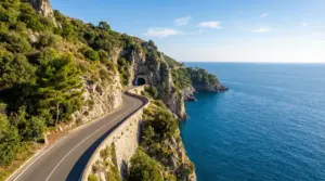 Strada panoramica sulla Costiera Amalfitana tra scogliere e mare azzurro, con galleria nella roccia