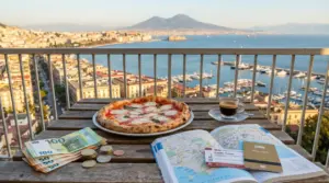 Pizza e caffè su un tavolo con contanti, mappa e tessera hotel, vista sul Golfo di Napoli e Vesuvio